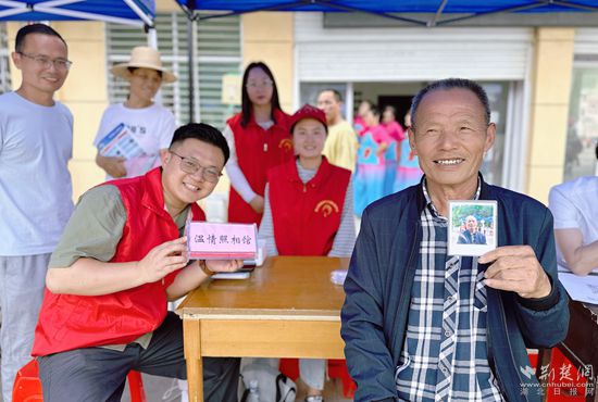 “溫情照相館”攤位上，前來(lái)照相的老人與志愿者開(kāi)心地合影留念_副本.jpg