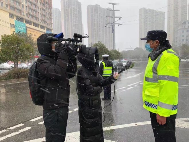 孝感市融媒體中心楊亞玲（風(fēng)雪中，采訪疫情期間重返一線的退休警察）_副本.jpg.jpg
